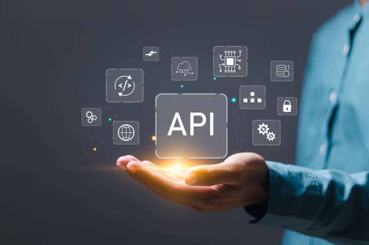 A hand holding glowing API text, surrounded by icons representing technology and data integration concepts.