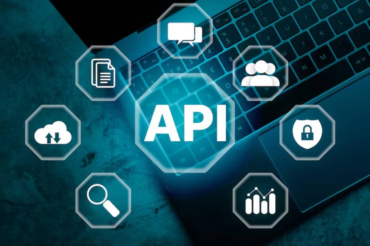 A laptop keyboard with hexagonal icons representing API features like cloud storage, security, communication, and analytics.