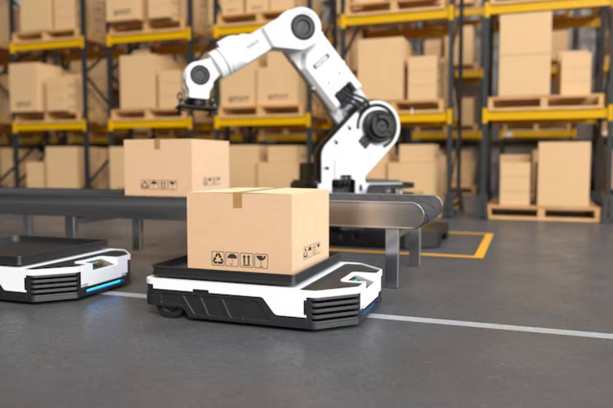 A robotic arm and autonomous carts handle cardboard boxes in a modern warehouse with stacked shelves in the background.