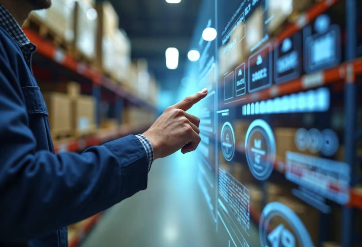 A person interacts with a digital interface displaying warehouse data, surrounded by shelves of packaged goods in a storage facility.